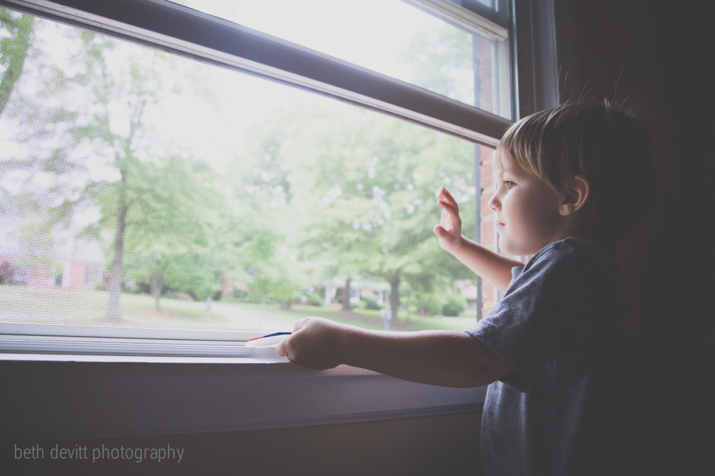 waving to his pals passing by on the street.  